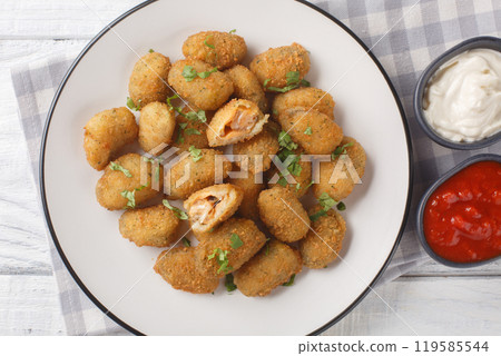 Seafood appetizer breaded mussels served with mayonnaise and ketchup close-up in a plate. Horizontal top view 119585544