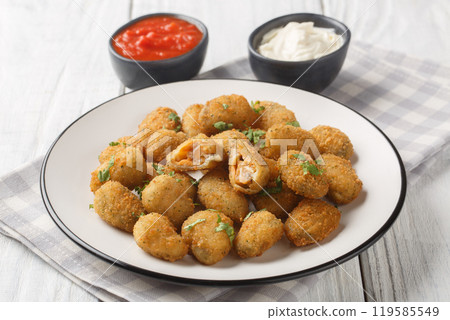 Deep fried breaded mussels served with mayonnaise and ketchup close-up in a plate. Horizontal 119585549