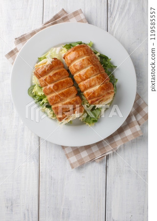 French puff pastry tubes stuffed with bechamel cheese sauce close-up in a plate. Vertical top view French puff pastry tubes stuffed with bechamel cheese sauce close-up in a plate. Vertical top view 119585557