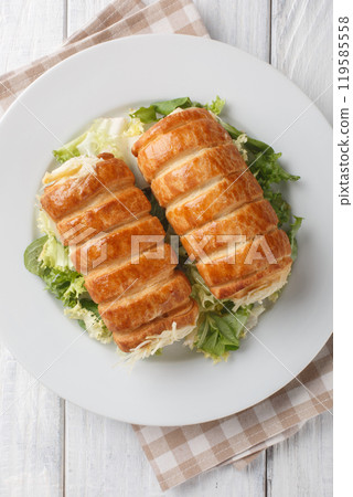 Roules au fromage typical French snack is made of puff pastry rolls filled with a cheesy Bechamel sauce closeup on the plate, Vertical top view 119585558