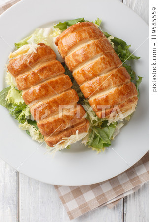 Savoury Puff pastry tubes stuffed with gruyere cheese and bechamel sauce close-up in a plate on the table. Vertical top view Savoury Puff pastry tubes stuffed with gruyere cheese and bechamel sauce close-up in a plate on the table. Vertical top view 119585559