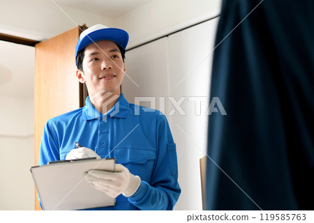 A male worker and a young male customer having a conversation in a room 119585763