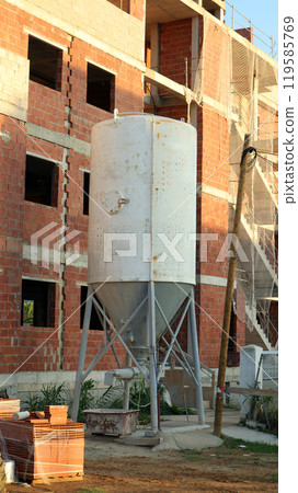 Concrete mixer preparing materials for construction of a commercial building during daylight hours Concrete mixer preparing materials for construction of a commercial building during daylight hours 119585769