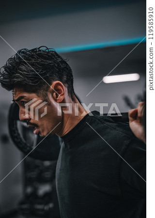 Man weight training with barbell at gym 119585910