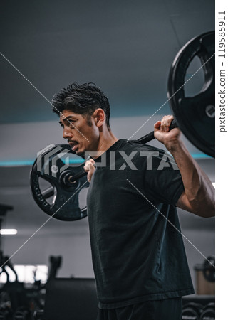 男子在健身房用槓鈴進行重量訓練 119585911