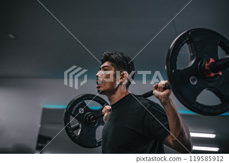 Man weight training with barbell at gym 119585912