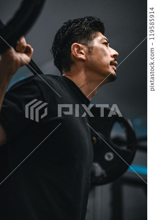 Man weight training with barbell at gym Man weight training with barbell at gym 119585914