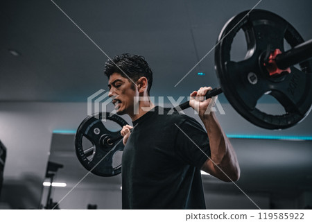Man weight training with barbell at gym Man weight training with barbell at gym 119585922