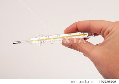 Medcine glass thermometer in hand on white 119586596
