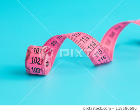 Pink centimeter tape measure on blue background 119586696