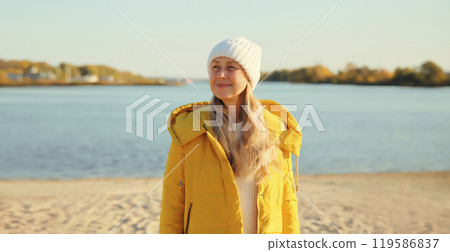 Traveler woman looking away on sunny beach, enjoying landscape on sea coast, nature background 119586837