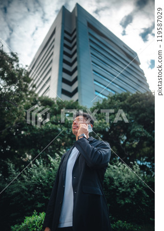 A man holding a smartphone among buildings A man holding a smartphone among buildings 119587029