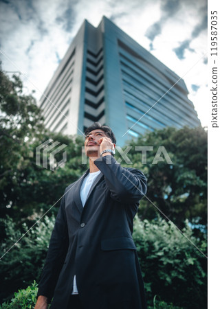 A man holding a smartphone among buildings 119587035