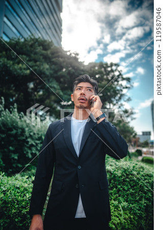 A man holding a smartphone among buildings A man holding a smartphone among buildings 119587046