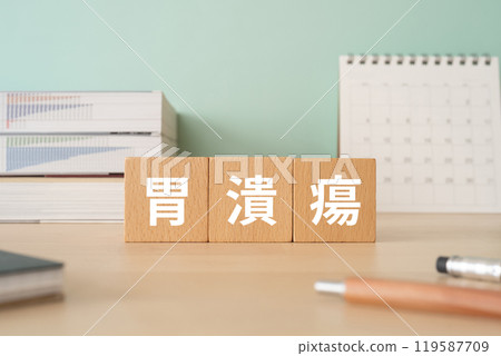 一張桌子上有一個木塊，上面寫著「胃潰瘍」兩個字。 119587709
