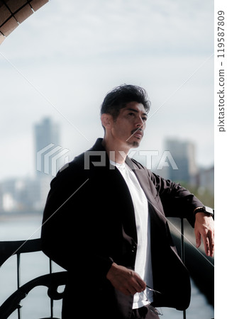 A man wearing a suit standing on the beach A man wearing a suit standing on the beach 119587809