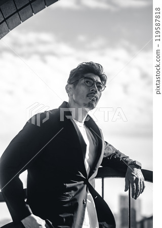 A man wearing a suit standing on the beach A man wearing a suit standing on the beach 119587818