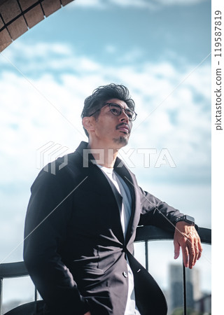 A man wearing a suit standing on the beach A man wearing a suit standing on the beach 119587819