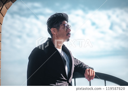 一個穿著套裝的男人站在海邊 一個穿著套裝的男人站在海邊 119587820