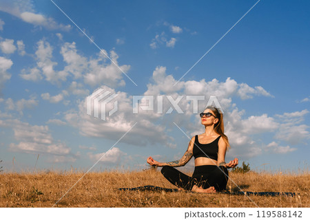 Woman Practicing Yoga Outdoors Early in Morning 119588142