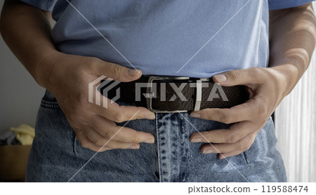 Leather belt on blue jeans. 119588474