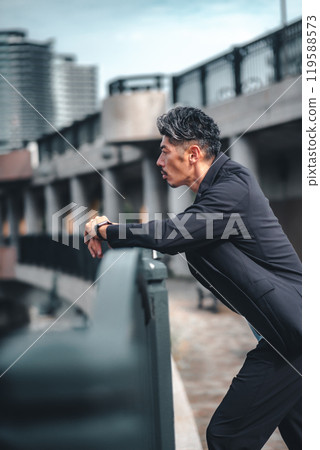 橋上的一個人在暮色中看起來很嚴肅 橋上的一個人在暮色中看起來很嚴肅 119588573