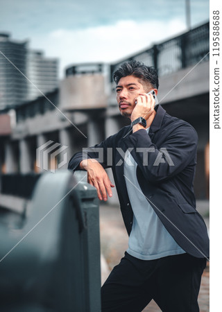 Man talking on mobile phone outdoors 119588688