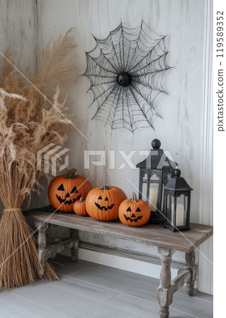 Cozy autumn decorations featuring pumpkins and spider accents in a rustic indoor setting 119589352