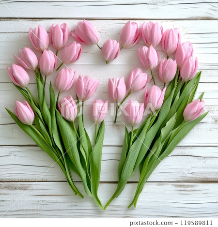 Pink tulips arranged in a heart shape on a wooden background for a romantic gesture Pink tulips arranged in a heart shape on a wooden background for a romantic gesture 119589811