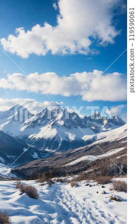 Vertical view of snow-covered mountain peaks with a clear blue sky and scattered clouds, highlighting the rugged terrain. 119590061
