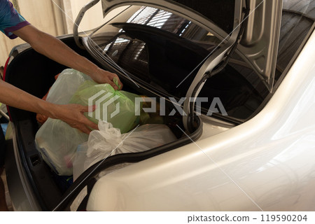 Loading Recyclable Waste into Car Trunk Loading Recyclable Waste into Car Trunk 119590204