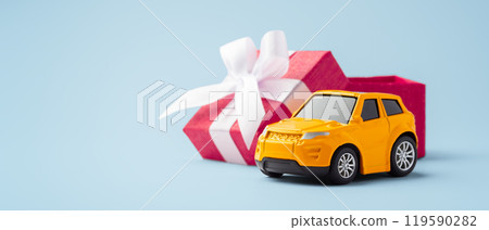 Car toy with red gift box opened on blue background Car toy with red gift box opened on blue background 119590282