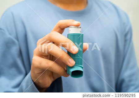 Asthma and chronic obstructive pulmonary disease COPD, Asian young man using metered dose inhaler MDI. Asthma and chronic obstructive pulmonary disease COPD, Asian young man using metered dose inhaler MDI. 119590295