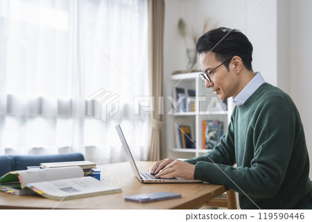 A man in his late 30s working on a laptop computer, profile A man in his late 30s working on a laptop computer, profile 119590446