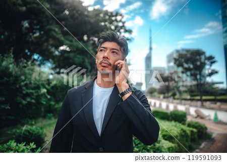 A man holding a smartphone among buildings A man holding a smartphone among buildings 119591093