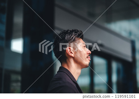 A man in a suit standing in front of a building 119591101