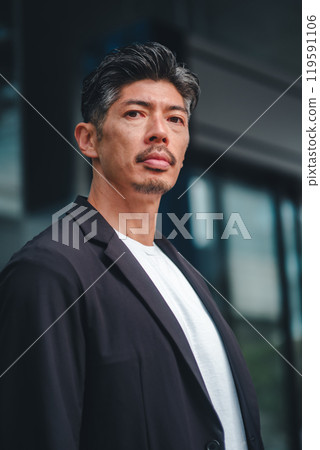 一個穿著西裝的男人站在大樓前 一個穿著西裝的男人站在大樓前 119591106