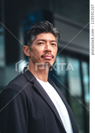 A man in a suit standing in front of a building 119591107