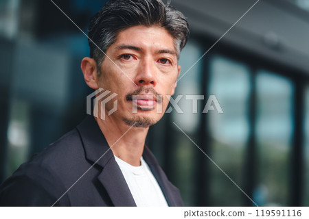 一個穿著西裝的男人站在大樓前 一個穿著西裝的男人站在大樓前 119591116