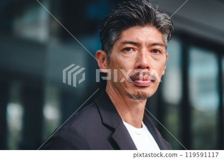 一個穿著西裝的男人站在大樓前 119591117