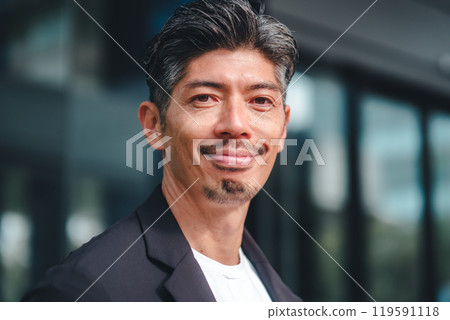 一個穿著西裝的男人站在大樓前 119591118