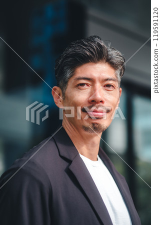 一個穿著西裝的男人站在大樓前 119591120