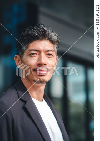 A man in a suit standing in front of a building 119591121