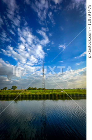 A breathtaking scenic view of a communication tower beautifully reflecting in calm water 119591478
