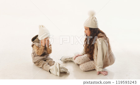Little one takes seat, covering his face as big sister watches on, sharing quiet moment on ice during their winter fun against white background. Little one takes seat, covering his face as big sister watches on, sharing quiet moment on ice during their winter fun against white background. 119593243