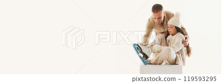 Banner. Father helps his daughter tie her skates, preparing her for exciting winter skating adventure against white background. 119593295