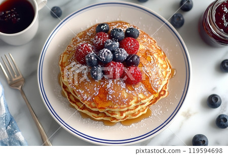 Delicious pancakes topped with fresh berries and syrup served with coffee on a rustic table 119594698
