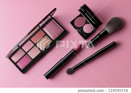 Vibrant makeup palette with brush and color powder on pink surface, showcasing beauty products 119595559