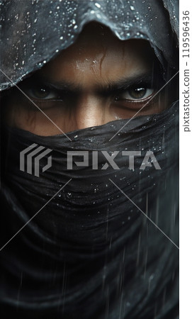 Close up of a mysterious figure with intense eyes wearing a dark cloth in a rainy environment 119596436