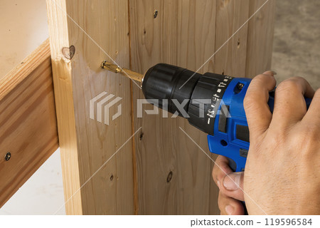 Close up scene the  power screw driver working with wooden plank. 119596584